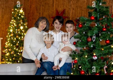 Glückliche Familie, neugeborenes Baby und ältere Brüder, Mutter zu Hause zu Weihnachten Stockfoto