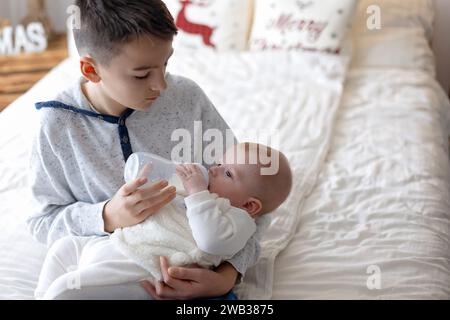 Glückliche Familie, neugeborenes Baby und ältere Brüder, Mutter zu Hause zu Weihnachten Stockfoto