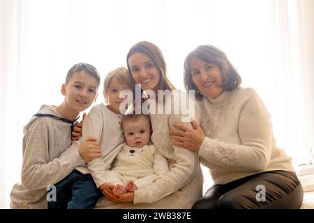 Glückliche Familie, neugeborenes Baby und ältere Brüder, Mutter zu Hause zu Weihnachten Stockfoto