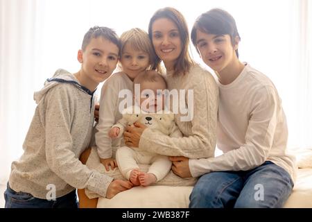 Glückliche Familie, neugeborenes Baby und ältere Brüder, Mutter zu Hause zu Weihnachten Stockfoto
