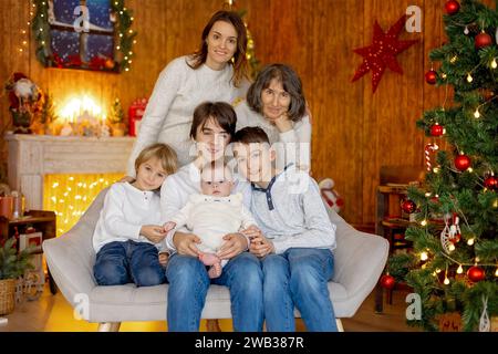 Glückliche Familie, neugeborenes Baby und ältere Brüder, Mutter zu Hause zu Weihnachten Stockfoto