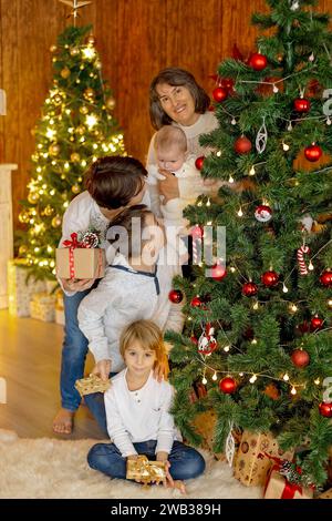 Glückliche Familie, neugeborenes Baby und ältere Brüder, Mutter zu Hause zu Weihnachten Stockfoto