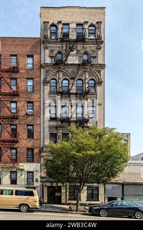 123 East 116th Street in East Harlem hat den größten Teil seiner aufwendigen Terrakotta intakt, obwohl das siebenstöckige Gebäude sein Gesims verloren zu haben scheint. Stockfoto