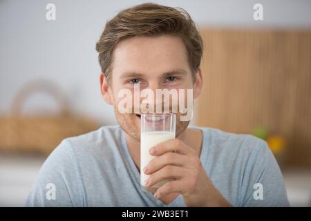 Hübscher, lächelnder vietnamesischer Mann mit einem Glas Milch Stockfoto
