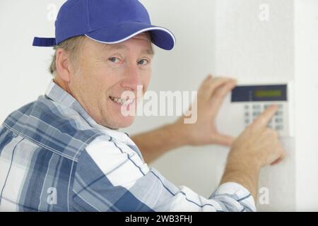 Reife man programmiert das elektronische Tastenfeld Stockfoto