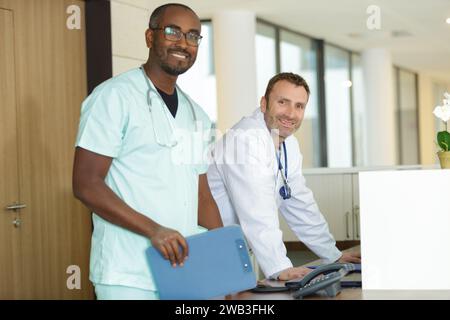 Junger Arzt, der an der Rezeption der Klinik arbeitet Stockfoto