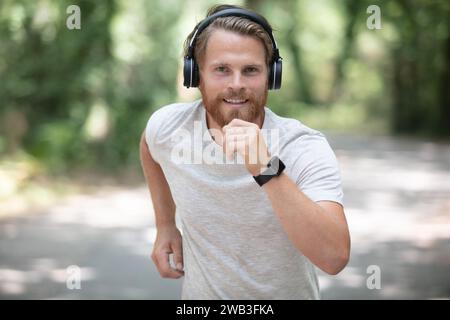 Sportlicher Mann läuft mit Smartwatch und Kopfhörern Stockfoto
