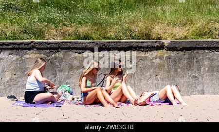 An einem glorreichen, heißen Tag in Dundee sonnen sich die einheimischen Frauen am Strand von Broughty Ferry während der Hitzewelle im Sommer in Schottland, Großbritannien Stockfoto