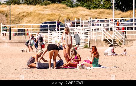 An einem glorreichen, heißen Tag in Dundee sonnen sich die einheimischen Frauen am Strand von Broughty Ferry während der Hitzewelle im Sommer in Schottland, Großbritannien Stockfoto