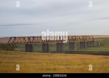 Eine alte Eisenbahnbrücke, die den Vaal River in Südafrika überquert, im frühen goldenen Licht Stockfoto