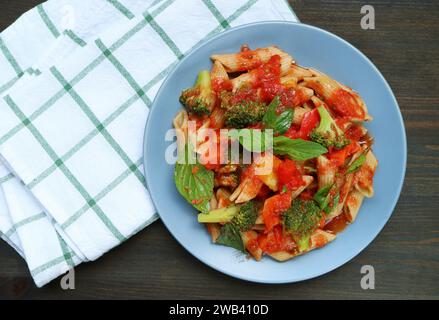 Teller mit frisch gekochter Penne-Pasta in Marinara-Sauce auf Küchentisch Stockfoto