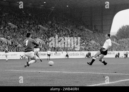 Dateifoto vom 12.07.1966 des Bundesministers Franz Beckenbauer (r) führt den Ball vorbei am Schweizer Torhüter Karl Elsener (l), um sein Team zum vierten Tor zu bringen. Beckenbauer, der die Bundesrepublik Deutschland als Kapitän und Manager zum WM-Ruhm führte, sei im Alter von 78 Jahren gestorben, sagte seine Familie in einer Stellungnahme vor der deutschen Nachrichtenagentur DPA. Ausgabedatum: Montag, 8. Januar 2024. Stockfoto