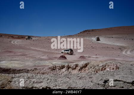 Sol de Mañana, Bolivien, 13. Oktober 2023. Geländewagen in der Wüste mit Bergen dahinter. Stockfoto