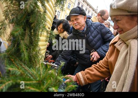 Nicht exklusiv: LEMBERG, UKRAINE - 6. JANUAR 2024 - die Menschen werden auf dem Rynok-Platz in der Epiphany, Lemberg, Westukraine, ihre Flaschen mit Weihwasser gefüllt. Stockfoto