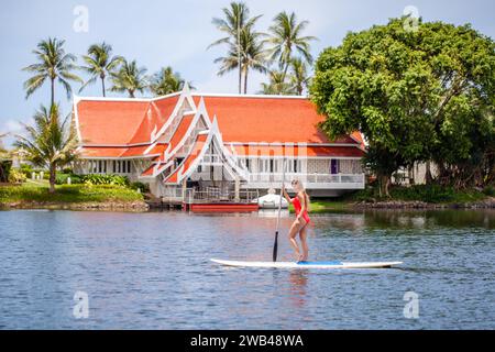 Frau paddelt auf ruhigem Wasser in der Nähe des tropischen Resorts. Abenteuer und Reisen. Stockfoto