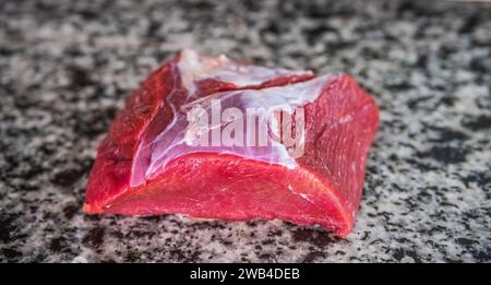 Frisches rotes Fleisch auf einem Marmorstein. Rotes Fleisch ist eine gute Quelle für Protein und Eisen. Rotes Fleisch versorgt uns mit Eisen, Zink und B-Vitaminen. Stockfoto