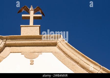 Kleine weiße Kapelle im traditionellen portugiesischen Stil an der Küste des Atlantiks, Kreuz auf dem Dach mit einer Möwe, die darauf sitzt, mit geöffnetem Wi Stockfoto