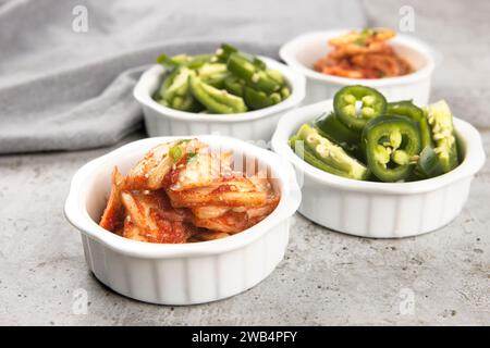Ein Nahaufnahme-Foto von Schüsseln koreanischer Kimchi und in Scheiben geschnittener Jalapeno-Paprika. Stockfoto