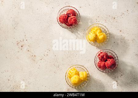 Mango- und Himbeersorbet in Glasschalen über dem Kopf Stockfoto