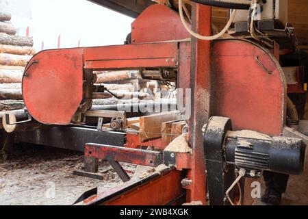 Verarbeitung von Holzbrettern in einem Sägewerk. Bei der Verarbeitung von Stämmen an der Ausrüstung des Sägewerks wird ein Baumstamm in Dielen geschnitten. Stockfoto