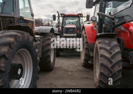 Kaiserslautern, Deutschland. Januar 2024. Traktor mit Protestschild wartet auf Vorführbeginn. Deutsche Bauern trafen sich in verschiedenen Teilen des Landes, um gegen die Pläne der Regierung zu protestieren, Agrarsubventionen zu reduzieren. Der bundesweite Protest wurde vom Deutschen Bauernverband (DBV) ab Montag, dem 8. Januar, initiiert und in der Woche fortgesetzt. Ziel ist es, das Bewusstsein zu erhöhen, indem Straßen mit landwirtschaftlichen Fahrzeugen blockiert und in Städten präsent sind. Die Demonstrationen werden zu schweren Staus in und um verschiedene Städte führen. Quelle: Gustav Zygmund/ Stockfoto