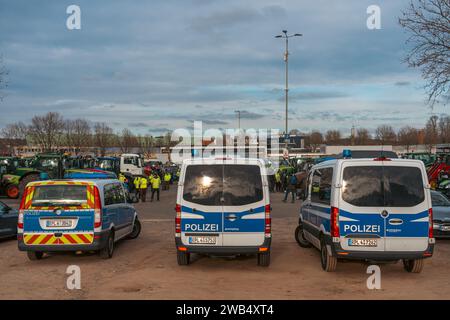 Kaiserslautern, Deutschland. Januar 2024. Drei Polizeiautos stehen am Messeplatz und sichern das Gelände vor Beginn des Protestes. Deutsche Bauern trafen sich in verschiedenen Teilen des Landes, um gegen die Pläne der Regierung zu protestieren, Agrarsubventionen zu reduzieren. Der bundesweite Protest wurde vom Deutschen Bauernverband (DBV) ab Montag, dem 8. Januar, initiiert und in der Woche fortgesetzt. Ziel ist es, das Bewusstsein zu erhöhen, indem Straßen mit landwirtschaftlichen Fahrzeugen blockiert und in Städten präsent sind. Die Demonstrationen werden zu schweren Staus in und um verschiedene Orte führen Stockfoto