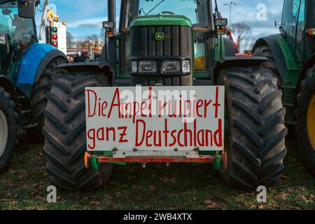 Kaiserslautern, Deutschland. Januar 2024. Traktor mit Protestschild am Messeplatz. Deutsche Bauern trafen sich in verschiedenen Teilen des Landes, um gegen die Pläne der Regierung zu protestieren, Agrarsubventionen zu reduzieren. Der bundesweite Protest wurde vom Deutschen Bauernverband (DBV) ab Montag, dem 8. Januar, initiiert und in der Woche fortgesetzt. Ziel ist es, das Bewusstsein zu erhöhen, indem Straßen mit landwirtschaftlichen Fahrzeugen blockiert und in Städten präsent sind. Die Demonstrationen werden zu schweren Staus in und um verschiedene Städte führen. Gustav Zygmund/Alamy News Stockfoto