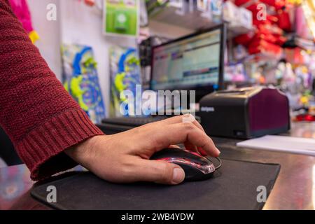 Ladenbesitzer Hand im Geschäft mit Kassenbildschirm im Hintergrund Stockfoto