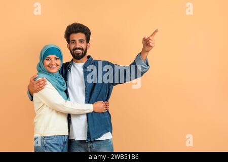 Arabisch-muslimisches Paar, das auf freien Raum zeigt, Stockfoto