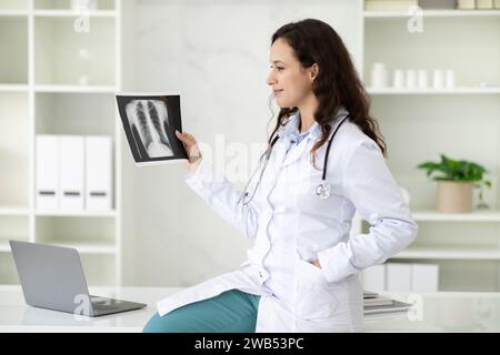 Glückliche junge Ärztin im Röntgenbild Stockfoto