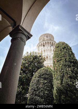 Eine vertikale Tiefwinkelaufnahme des Turms von Pisa in der Nähe von Hecken Stockfoto