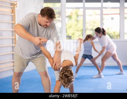Vater lehrt seinen Sohn, in Selbstverteidigungskursen kraftvolle Techniken und Griffe anzuwenden Stockfoto