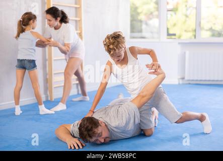 Vater lehrt seinen Sohn, in Selbstverteidigungskursen kraftvolle Techniken und Griffe anzuwenden Stockfoto