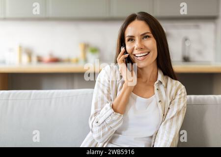 Schöne junge Frau, die zu Hause telefoniert Stockfoto