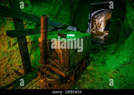 Schmutzige verlassene Uranmine mit rostiger Schiene und Rollwagen. Stockfoto