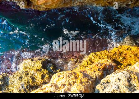 Schaumige Felsenriffe, Klippenfelsen gelb, mediterranes Wasser von Antalya türkei felsige Klippen, Wasserschaum poröse Steine verwittert Stockfoto