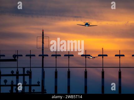 Landebahnbefeuerung, Anflughilfen, auf dem Flughafen Düsseldorf International, Sonnenuntergang, Flieger beim Start und im Landeanflug auf die Hauptbahn Süd, 05R/23L, NRW, Deutschland, Luftfahrt *** Start- und Landebahnbeleuchtung, Anflughilfen, am Flughafen Düsseldorf International, Sonnenuntergang, Flugzeuge, die auf der Südbahn starten und sich nähern, 05R 23L, NRW, Deutschland, Luftfahrt, Luftfahrt Stockfoto