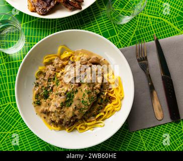 Blick von oben auf Schweineribs mit Pilzsauce und Linguine Stockfoto