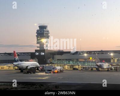 Afines, Griechenland - 20. august 2023: Passagierflugzeuge stehen bei Sonnenuntergang in der Nähe von Flughafenterminals Stockfoto