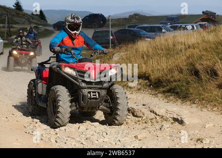 Mann, der ein modernes Quad auf einer sandigen Straße fährt. Extremsport Stockfoto