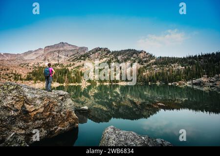 Frau blickt über den Haiyaha Lake im Rocky Mountain National Park Stockfoto