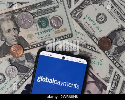 Bayern, Deutschland - 9. Januar 2024: In dieser Fotoabbildung wird ein Global Payments Logo auf einem Smartphone mit US-Dollar-Banknoten angezeigt Stockfoto