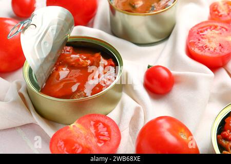 Geöffnete Dose mit Fisch in Sauce und Tomaten auf Serviette Stockfoto