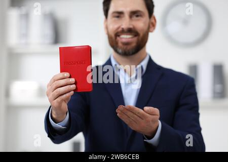 Einwanderung. Glücklicher Mann mit Pass drinnen, selektiver Fokus Stockfoto