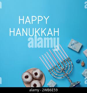 Happy Hanukkah. Menora, Donuts, Dreidels und Geschenke auf hellblauem Hintergrund, flach Stockfoto