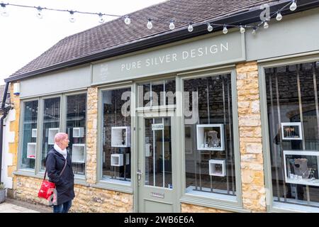 Model hat eine Frau veröffentlicht, die Silberschmuck in einem Geschäft in Stow on the Wold cotswolds kauft, Schaufenstergeschäft ist geschlossen, England, 2023 Stockfoto