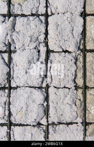 Textur von handgemachtem Papier auf einem schwarzen Metallgitter. Stockfoto