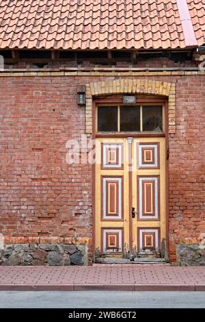 Gelbe, rote und weiße Farbe an der getäfelten Eingangstür eines traditionellen estnischen Hauses, Viljandi, Estland. Stockfoto