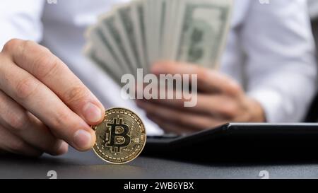 Bitcoin-Münze digitales Gold neben Expert Trader Hands, die Einkommensscheine in Dollar-Bargeld zählen. Nahaufnahme der Hände unerkennbarer Freelancer. Verdientes Handelsdiagramm Wachstum Kryptowährung Marktinvestitionskonzept. American Bucks finanziert Einsparungen Stockfoto