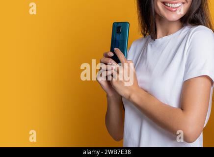 Frau versteckt Telefon, zugeschnittene Ansicht. Frau mit Smartphone. Chatten und SMS schreiben. Online verbunden. Private Nachricht. SMS-Kommunikation. Mädchen chatten Stockfoto